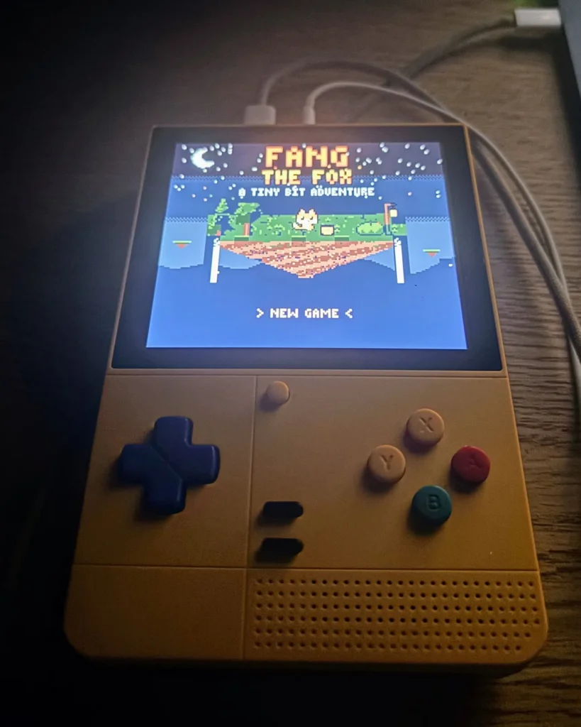 A Retroid Pocket handheld showing the Fang the Fox title screen in Game Boy Color pixel art